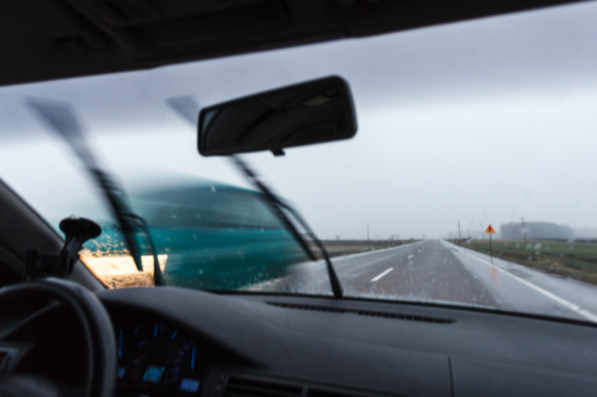 Blue car passing by during rainy weather | MAS Law